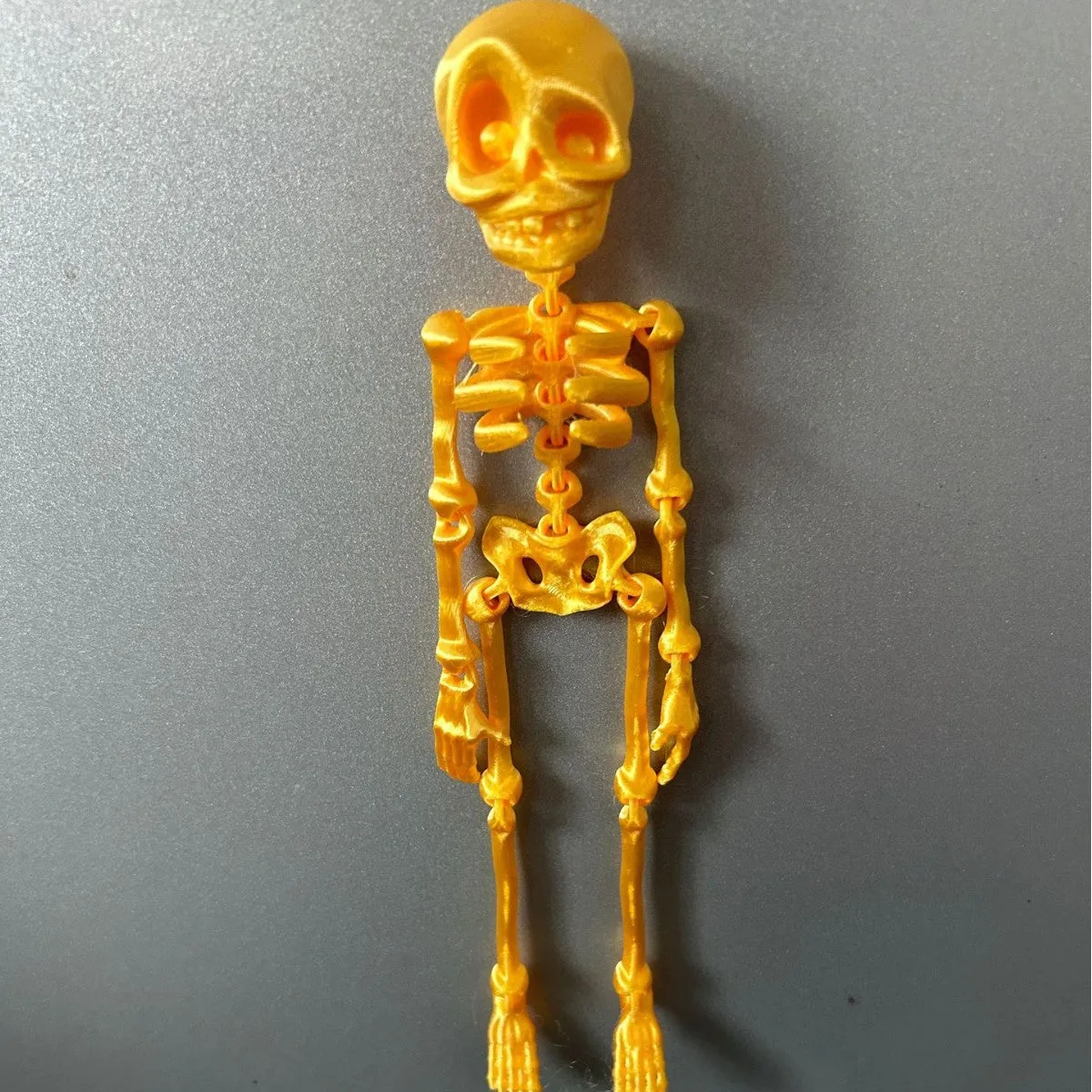 3D printed skull refrigerator magnet in multiple colours measuring 18cm high by 4.5cm wide