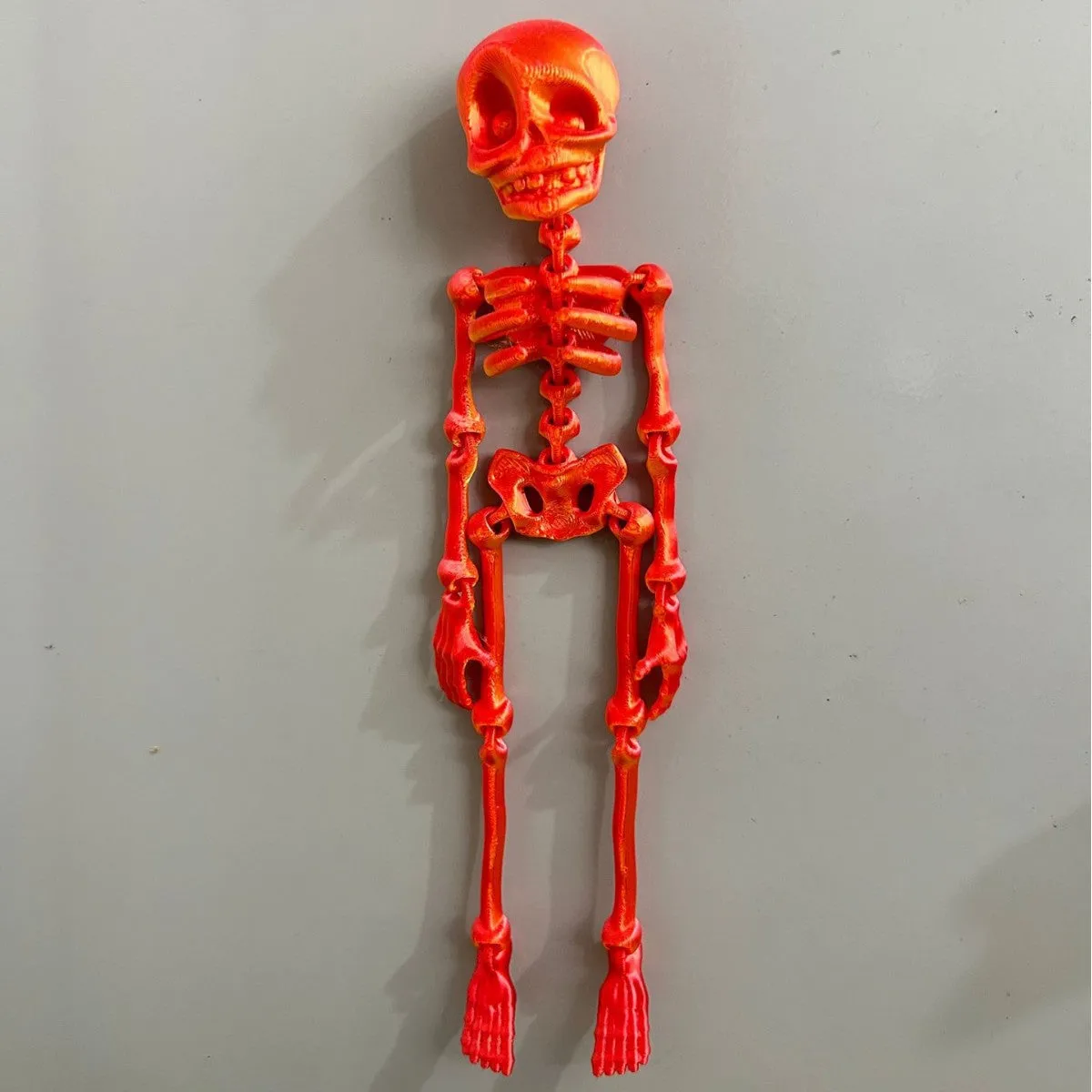3D printed skull refrigerator magnet in multiple colours measuring 18cm high by 4.5cm wide