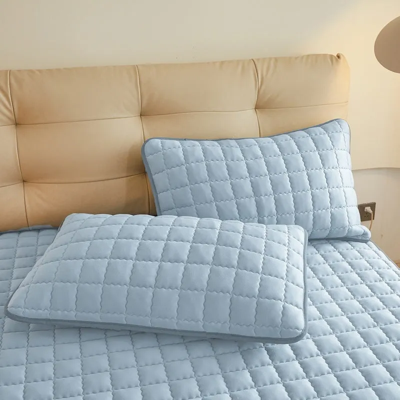 Blue waterproof fitted sheet with elasticated corners on a mattress.