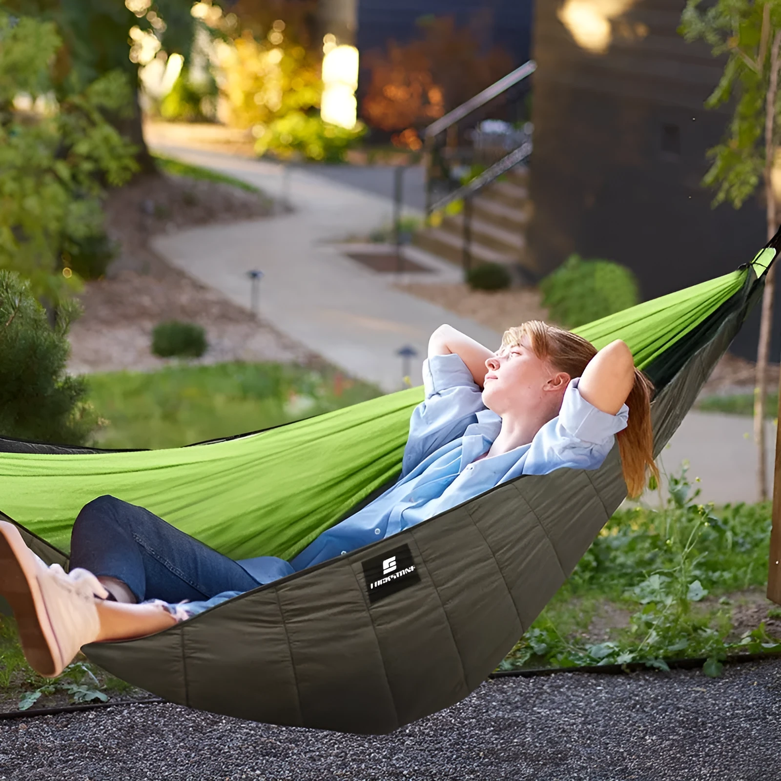 Army green thickened camping hammock sleeping bag with compression bag, shown in an outdoor setting.