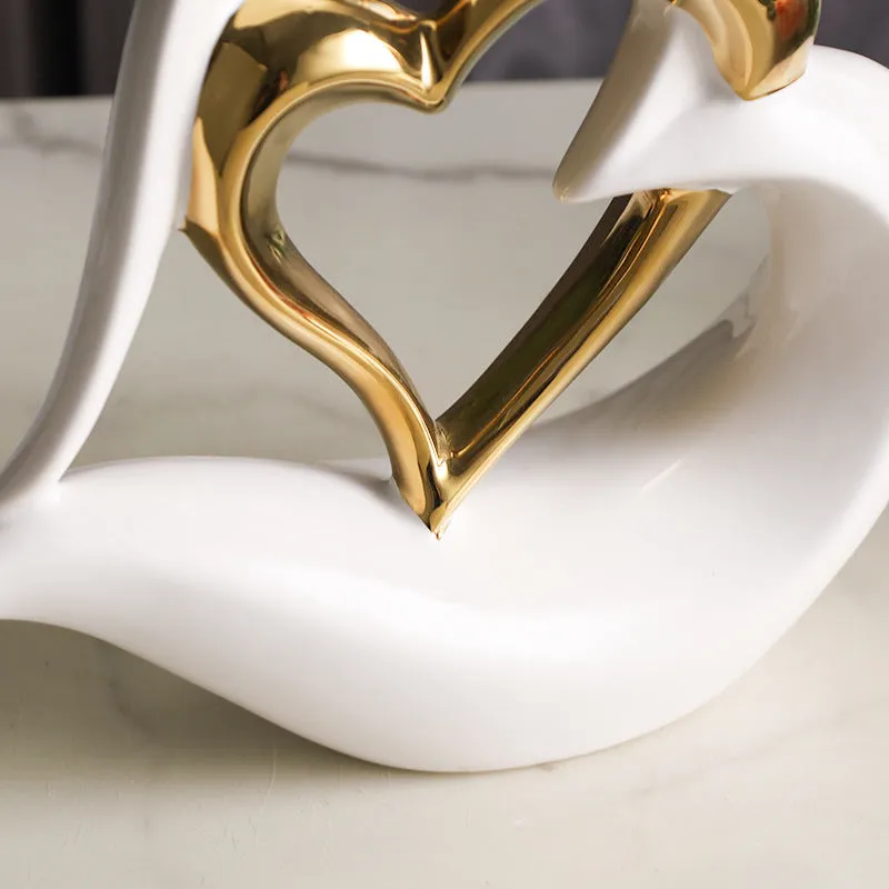 Modern geometric heart ornament in metallic finish displayed on shelf
