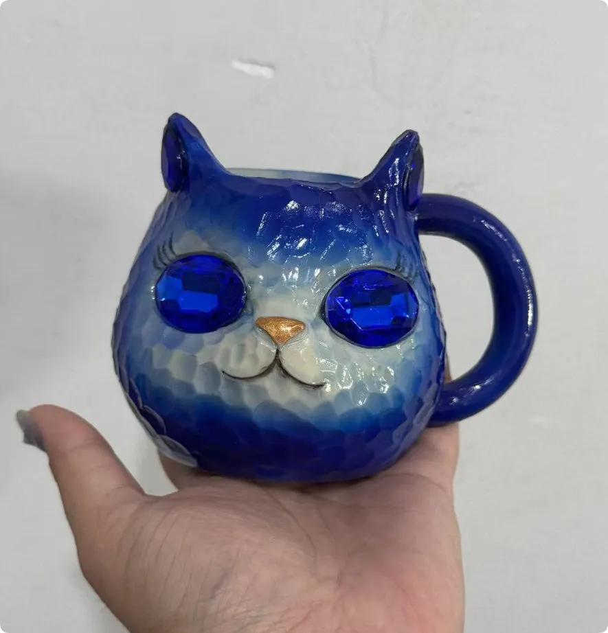 Colourful resin cat cup figurine on a shelf, shown in purple, green, blue, and pink colour options.