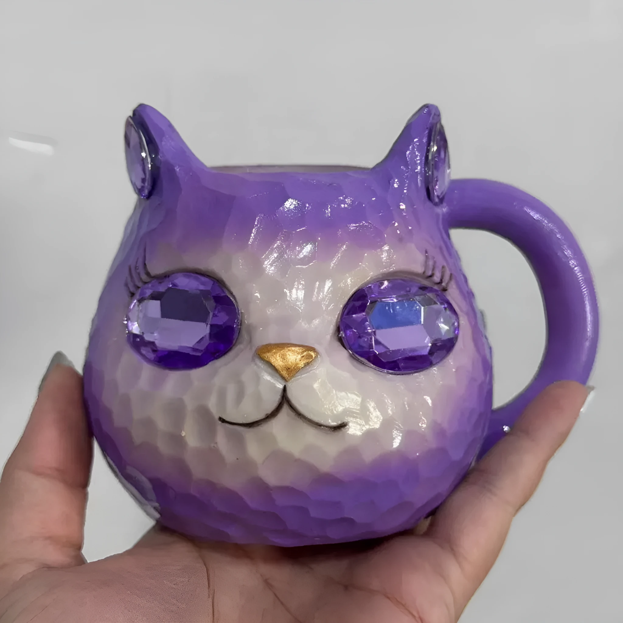 Colourful resin cat cup figurine on a shelf, shown in purple, green, blue, and pink colour options.