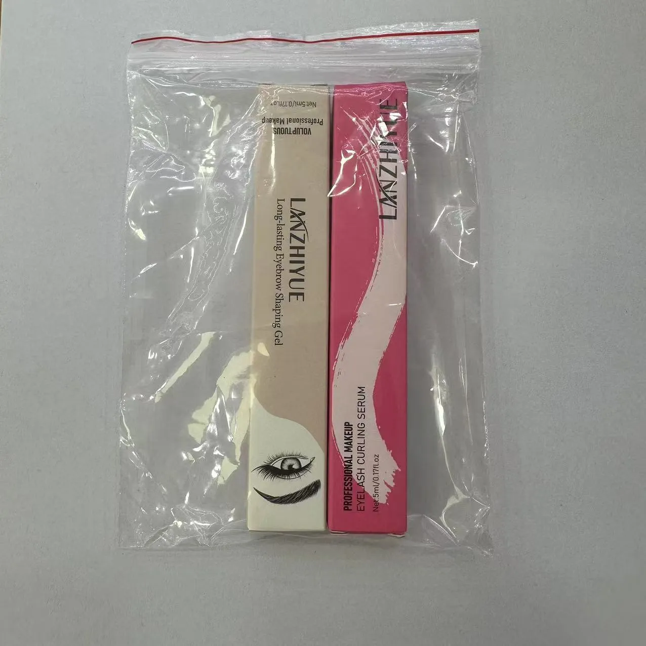 White eyelash growth liquid with applicator brush for lash thickening