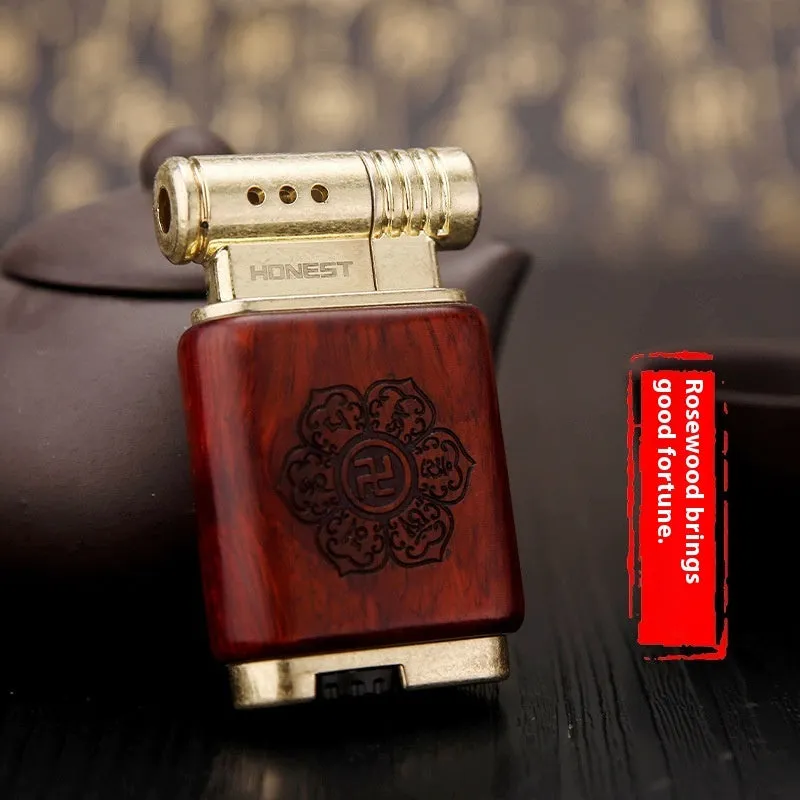 Decorative rosewood and blackwood gas lighter with sun face engraving on metal body.