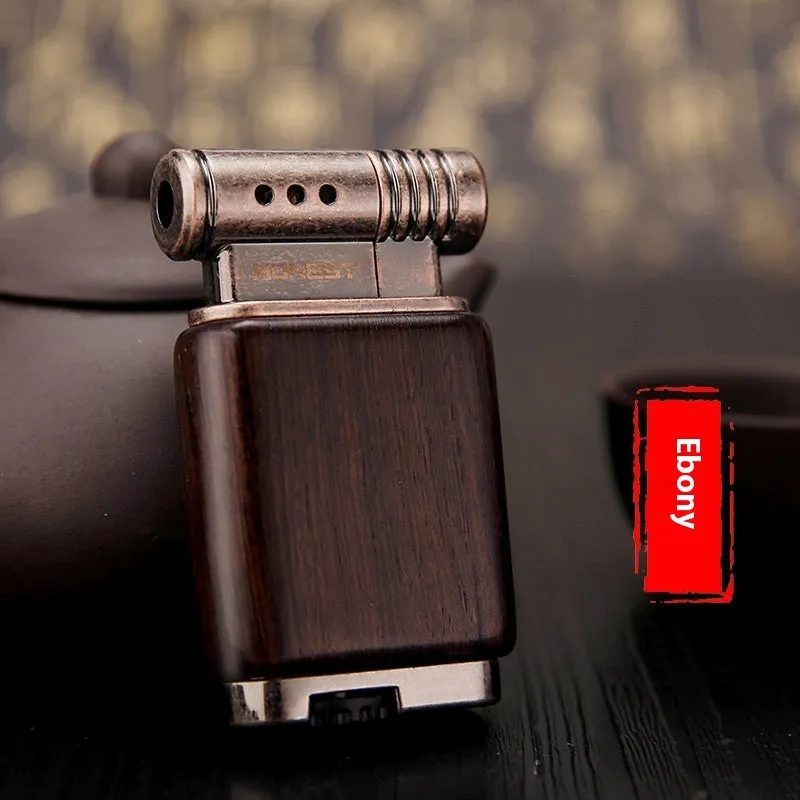 Decorative rosewood and blackwood gas lighter with sun face engraving on metal body.