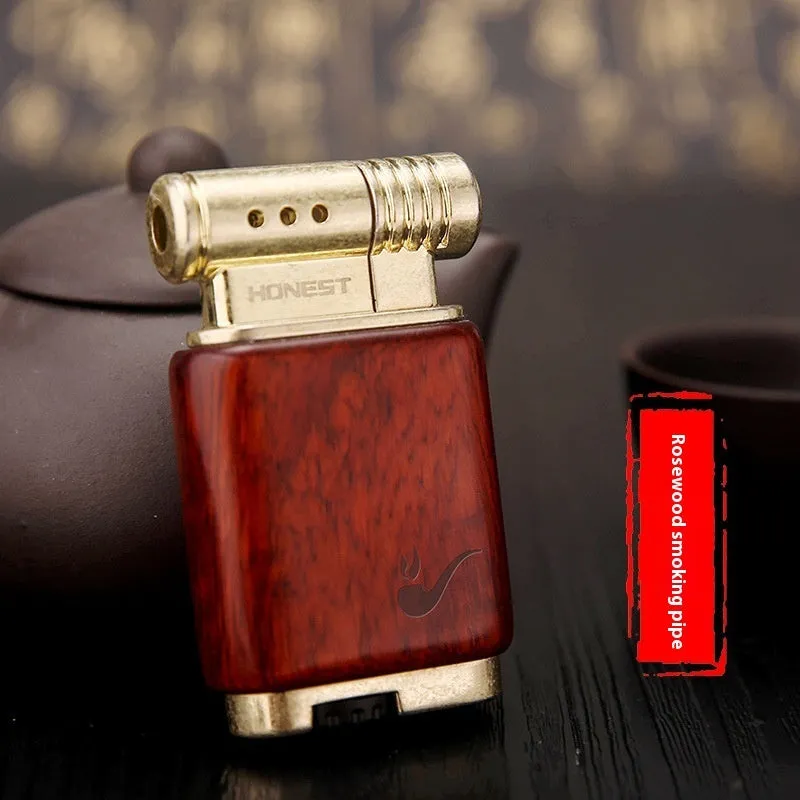 Decorative rosewood and blackwood gas lighter with sun face engraving on metal body.