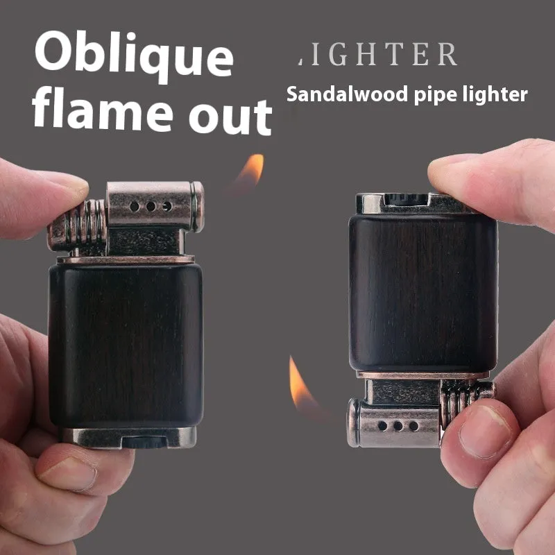 Decorative rosewood and blackwood gas lighter with sun face engraving on metal body.