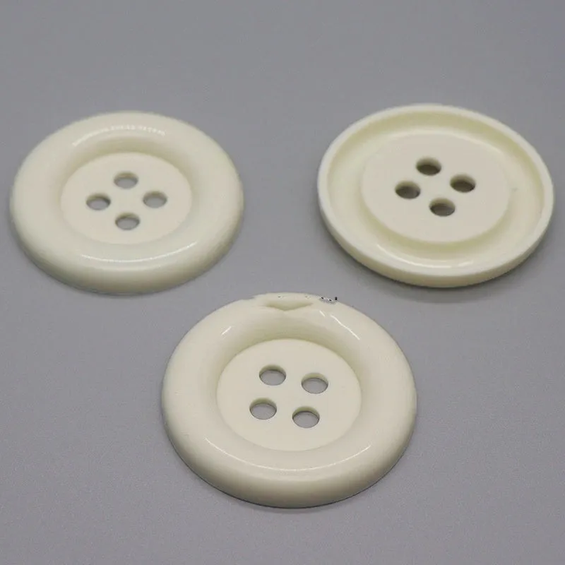 Oversized round edge plastic button with four holes in various colours and diameter sizes
