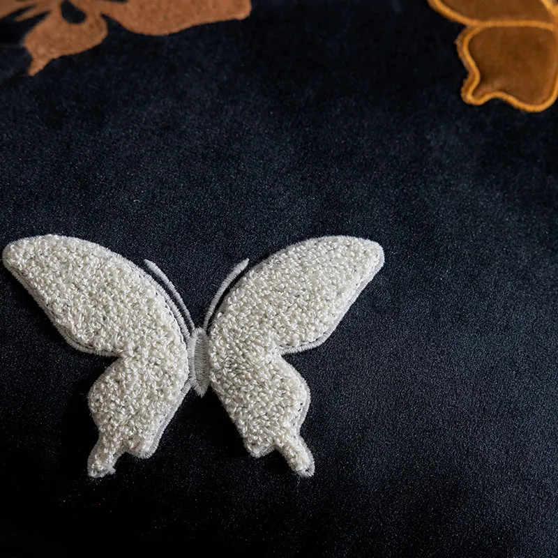 Square beige cushion with embroidered Chinese-style butterfly design.