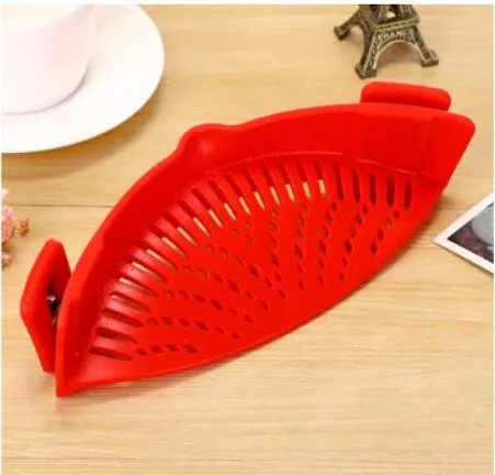Silicone clip-on kitchen strainer with stainless steel frame attached to pot rim for draining liquids