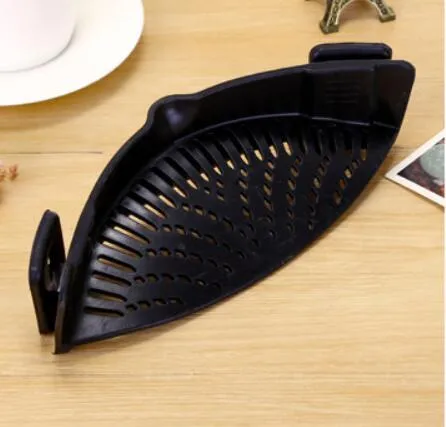 Silicone clip-on kitchen strainer with stainless steel frame attached to pot rim for draining liquids