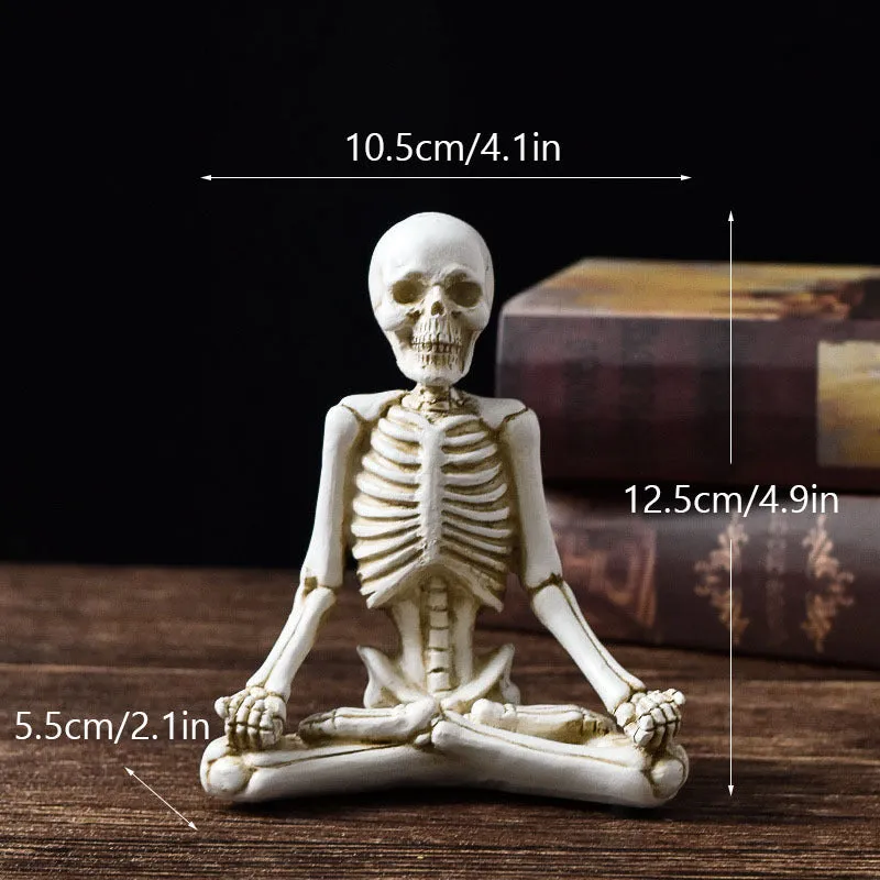 Hand-painted resin yoga pose skull skeleton ornament measuring 10.5-11cm wide on wooden desktop