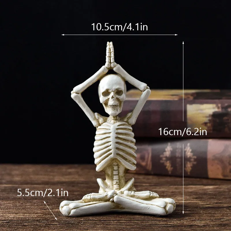 Hand-painted resin yoga pose skull skeleton ornament measuring 10.5-11cm wide on wooden desktop