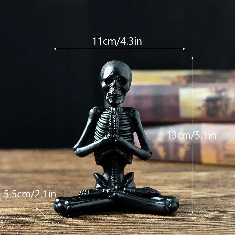 Hand-painted resin yoga pose skull skeleton ornament measuring 10.5-11cm wide on wooden desktop