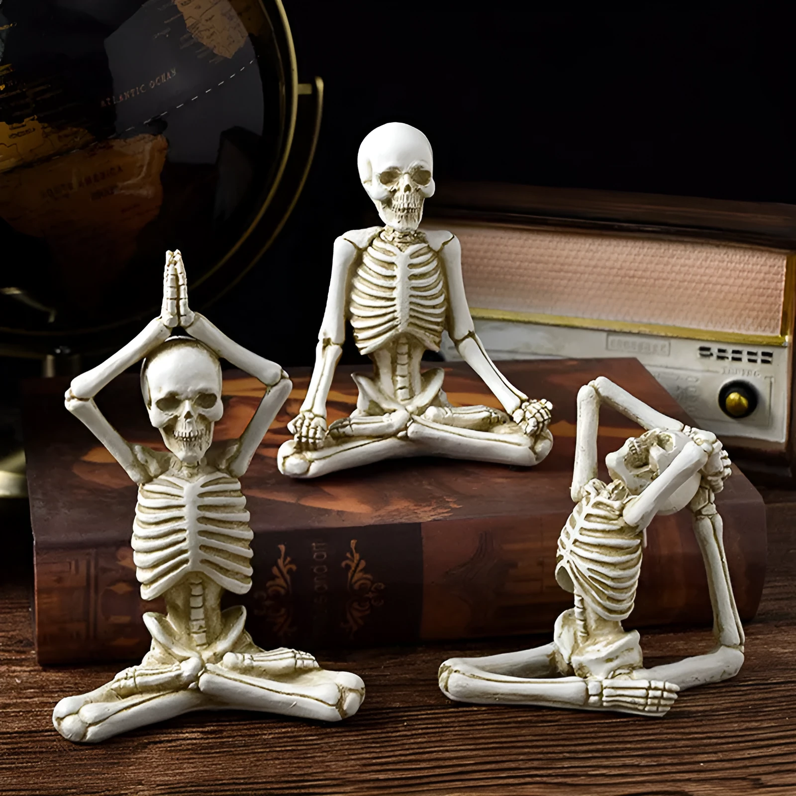 Hand-painted resin yoga pose skull skeleton ornament measuring 10.5-11cm wide on wooden desktop