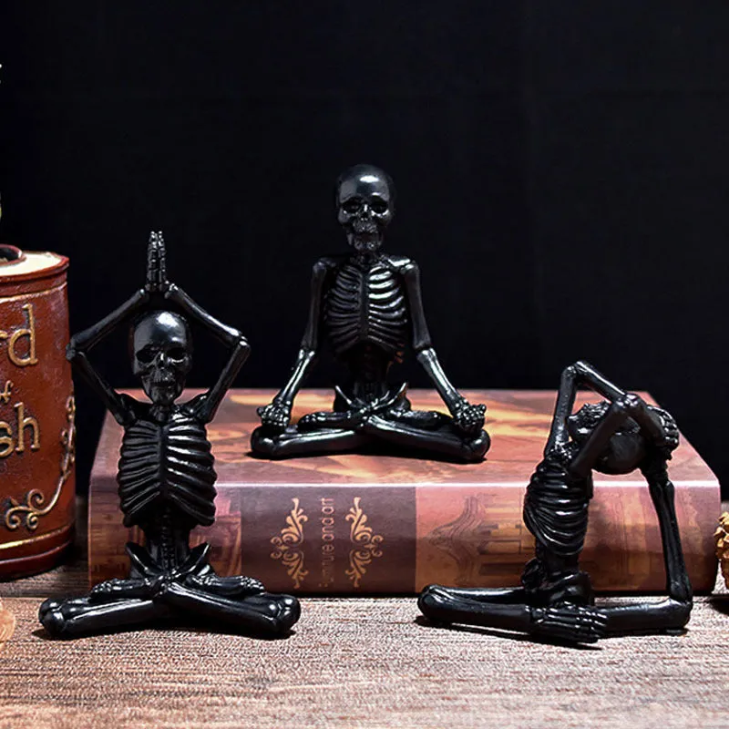 Hand-painted resin yoga pose skull skeleton ornament measuring 10.5-11cm wide on wooden desktop