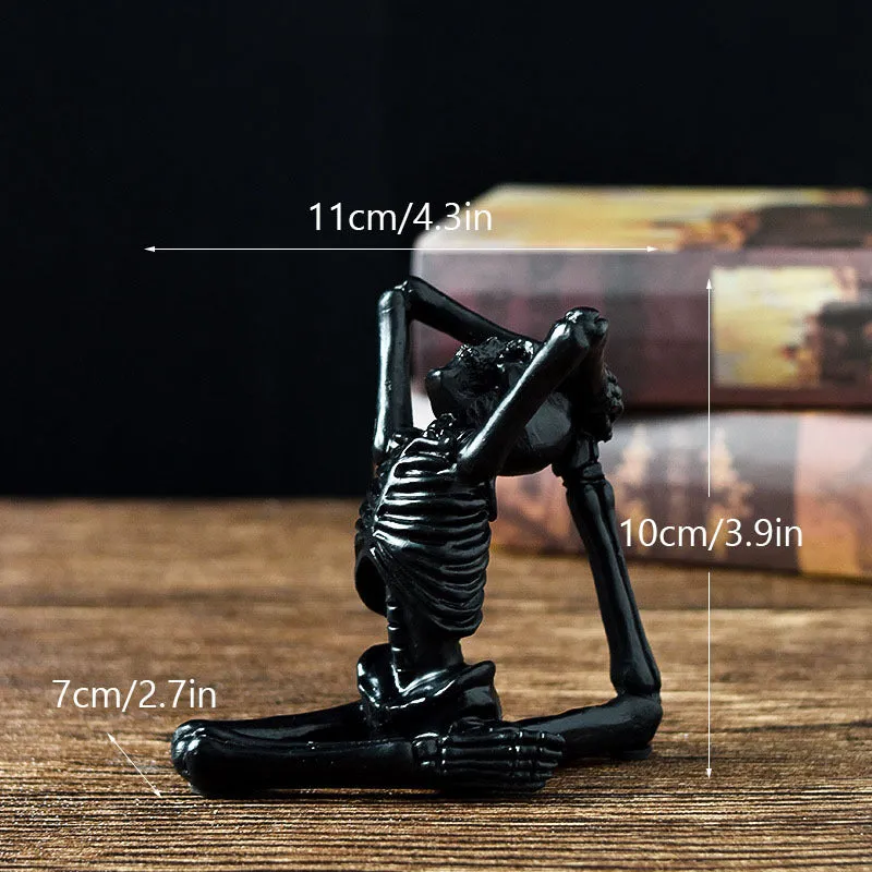 Hand-painted resin yoga pose skull skeleton ornament measuring 10.5-11cm wide on wooden desktop