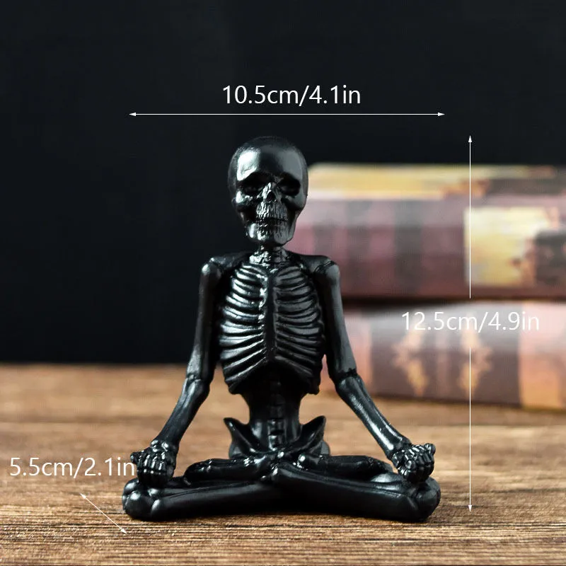 Hand-painted resin yoga pose skull skeleton ornament measuring 10.5-11cm wide on wooden desktop