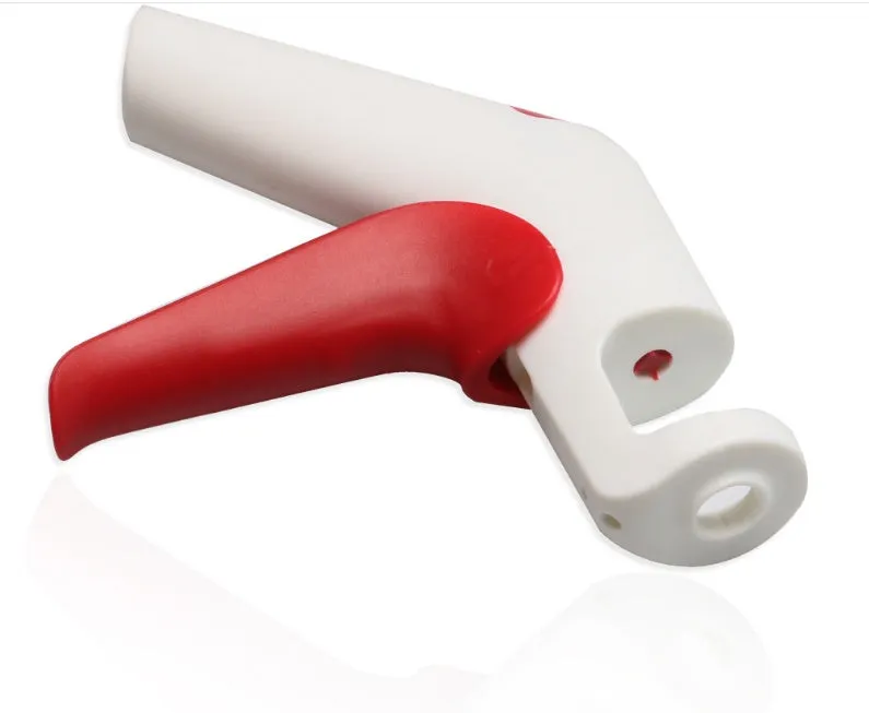 Stainless steel manual cherry pitter tool with protective end caps on a wooden surface.