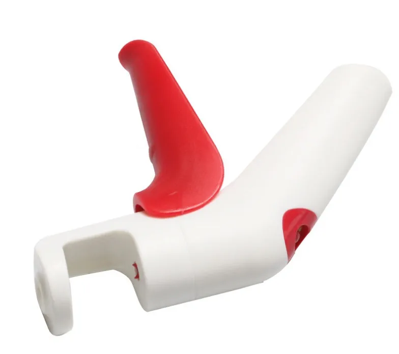 Stainless steel manual cherry pitter tool with protective end caps on a wooden surface.