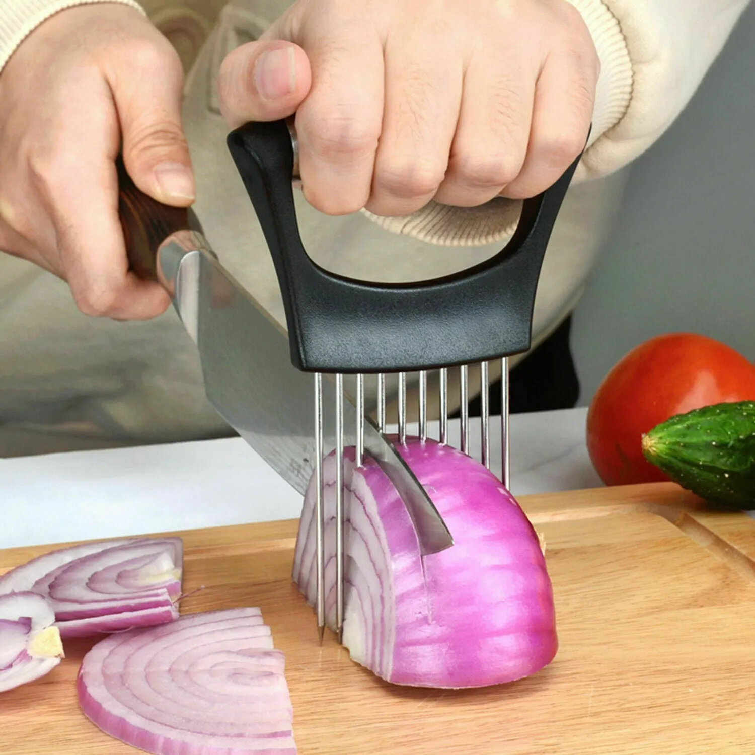 Stainless steel onion and tomato holder slicer with ABS handle on a kitchen worktop.