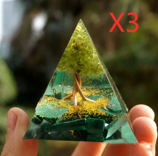 Small 6cm high clear epoxy resin pyramid ornament filled with colourful natural crystal gravel on a shelf.