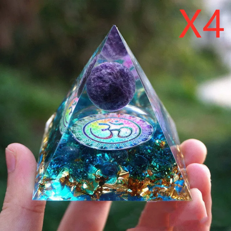 Small 6cm high clear epoxy resin pyramid ornament filled with colourful natural crystal gravel on a shelf.
