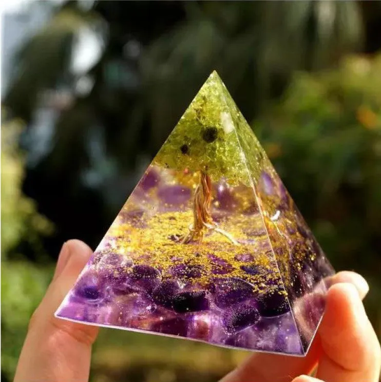 Small 6cm high clear epoxy resin pyramid ornament filled with colourful natural crystal gravel on a shelf.