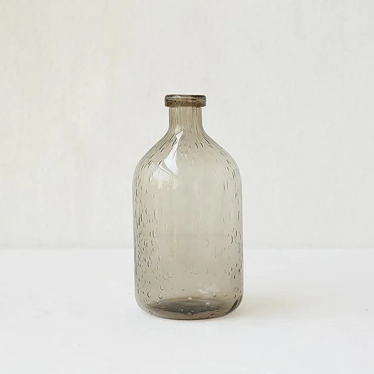 Grey geometric bubble-shaped stained glass vase on a wooden surface.