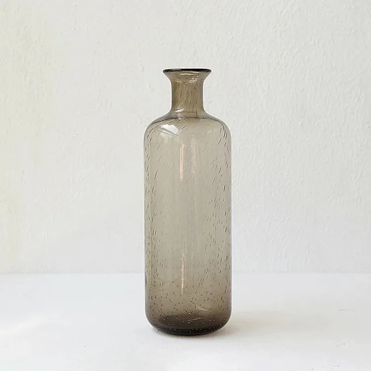 Grey geometric bubble-shaped stained glass vase on a wooden surface.