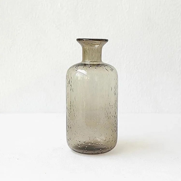 Grey geometric bubble-shaped stained glass vase on a wooden surface.