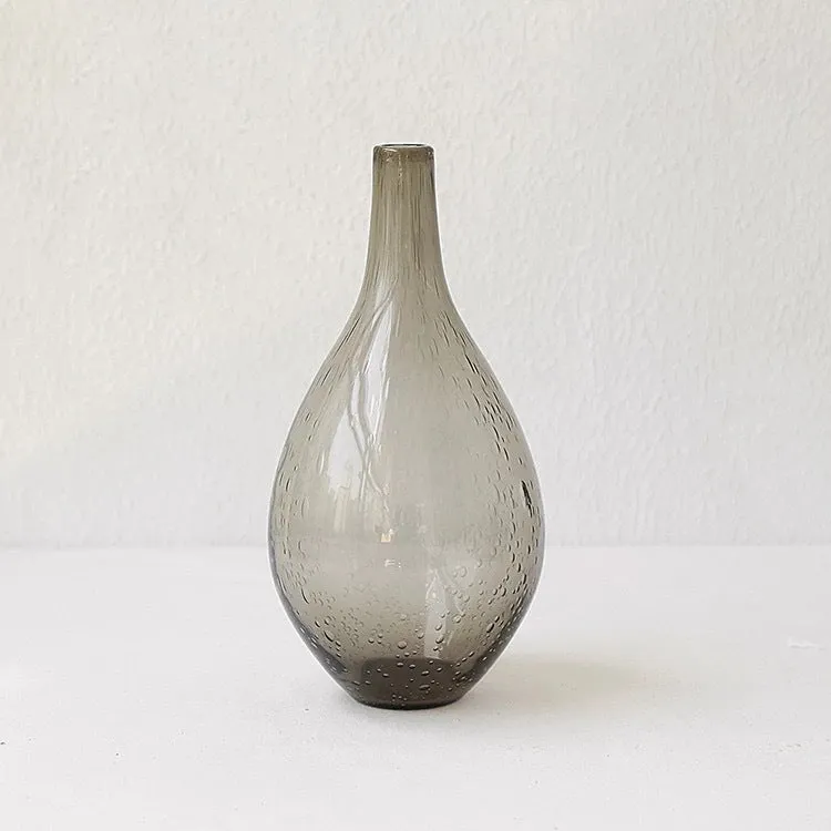 Grey geometric bubble-shaped stained glass vase on a wooden surface.