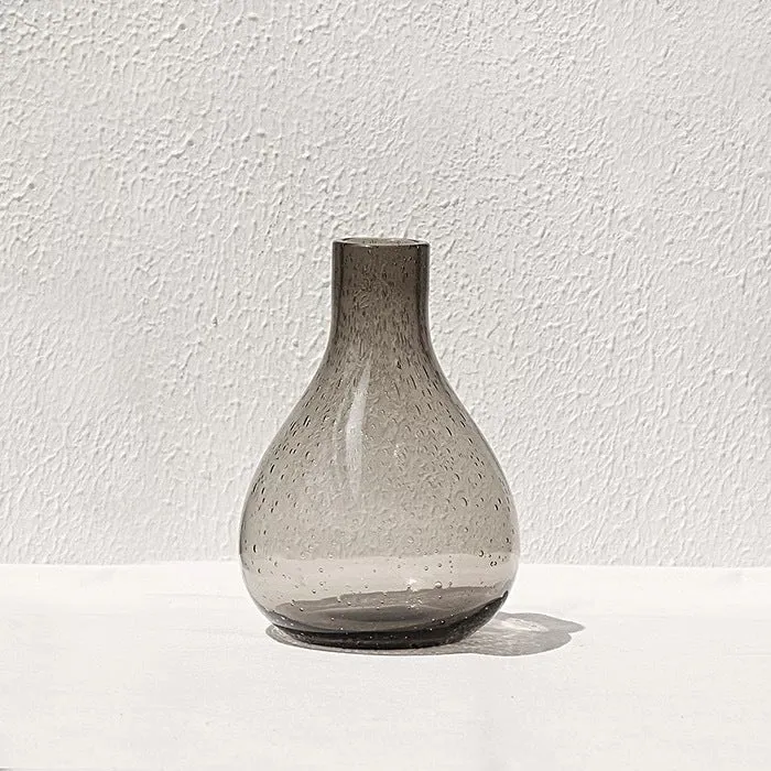 Grey geometric bubble-shaped stained glass vase on a wooden surface.