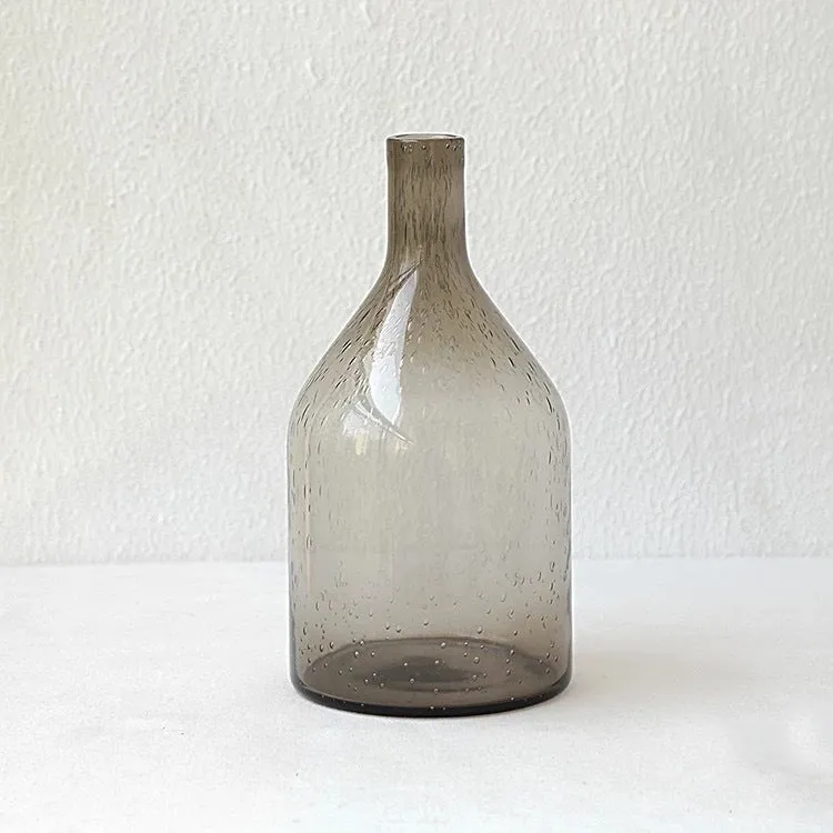Grey geometric bubble-shaped stained glass vase on a wooden surface.