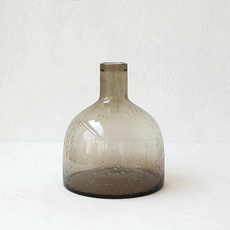 Grey geometric bubble-shaped stained glass vase on a wooden surface.