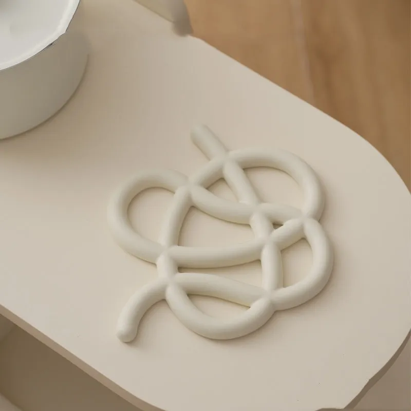 Ceramic heatproof mat in an irregular shape on a kitchen countertop.