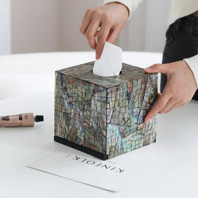 A black square natural shell storage box with a removable white internal organiser on a wooden table.