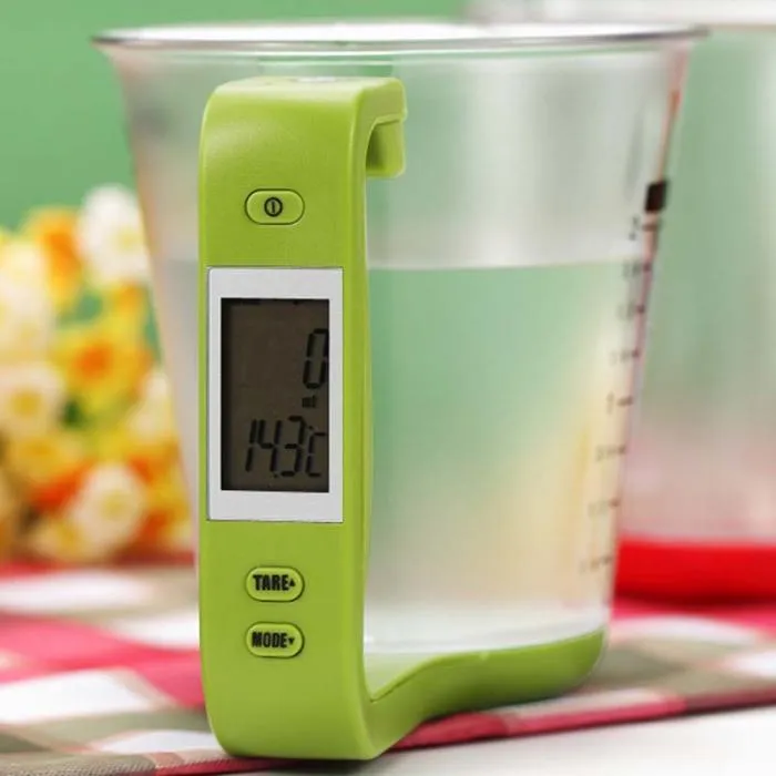 Green digital measuring cup scale with LCD display showing weight measurement