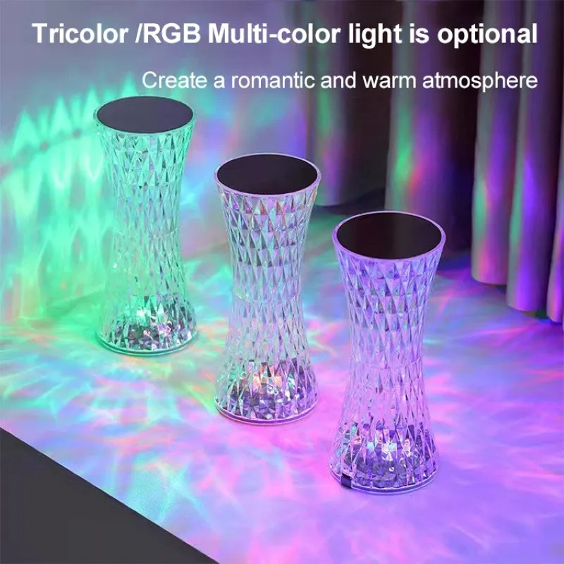 Vase-shaped transparent crystal bedside lamp with touch controls and LED lights on a table.
