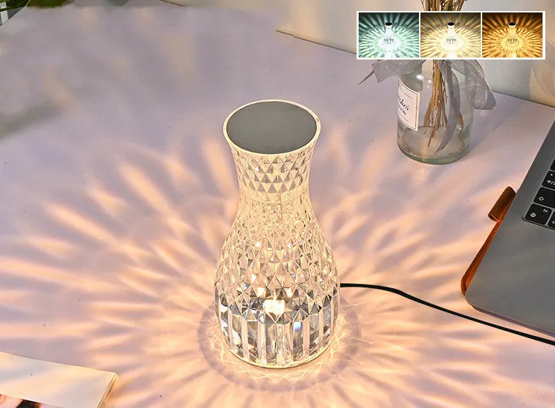 Vase-shaped transparent crystal bedside lamp with touch controls and LED lights on a table.