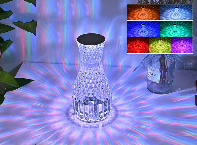 Vase-shaped transparent crystal bedside lamp with touch controls and LED lights on a table.