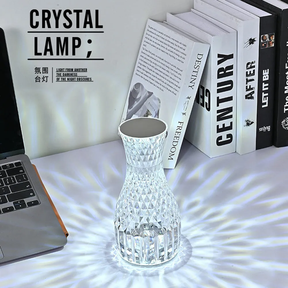 Vase-shaped transparent crystal bedside lamp with touch controls and LED lights on a table.
