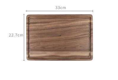 Solid black walnut wood chopping board with a deep perimeter groove and a side handle, shown as a serving tray.