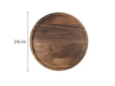 Solid black walnut wood chopping board with a deep perimeter groove and a side handle, shown as a serving tray.