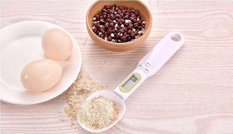 Black digital measuring spoon scale showing 0.0g display on LCD screen with 500g capacity