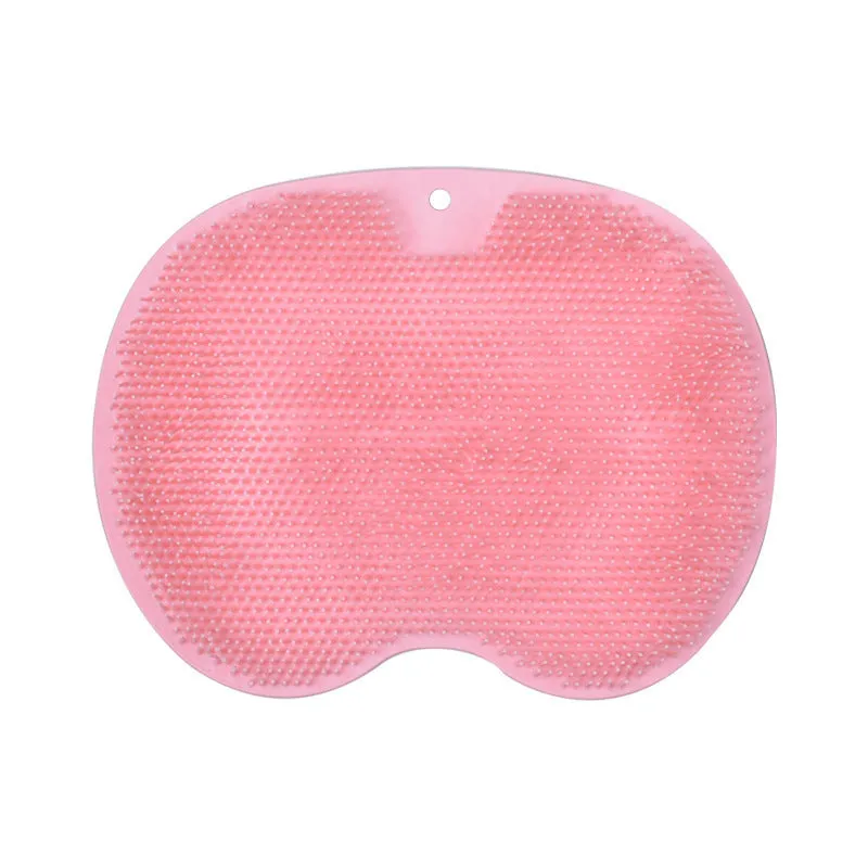 Orange non-slip massage bath brush with suction cups and soft silicone bristles on a bathroom floor.