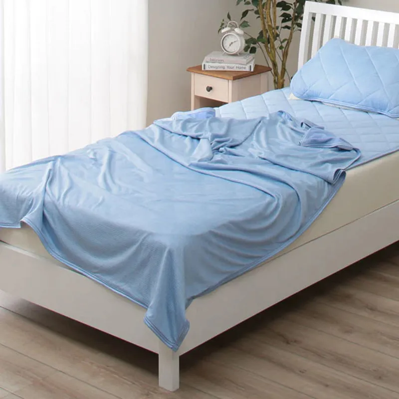 Blue and grey polyester cooling blanket with Japanese Q-Max fibres on a bed.