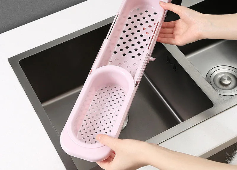 Blue grey telescopic sink rack holding a sponge and soap bar next to a kitchen tap