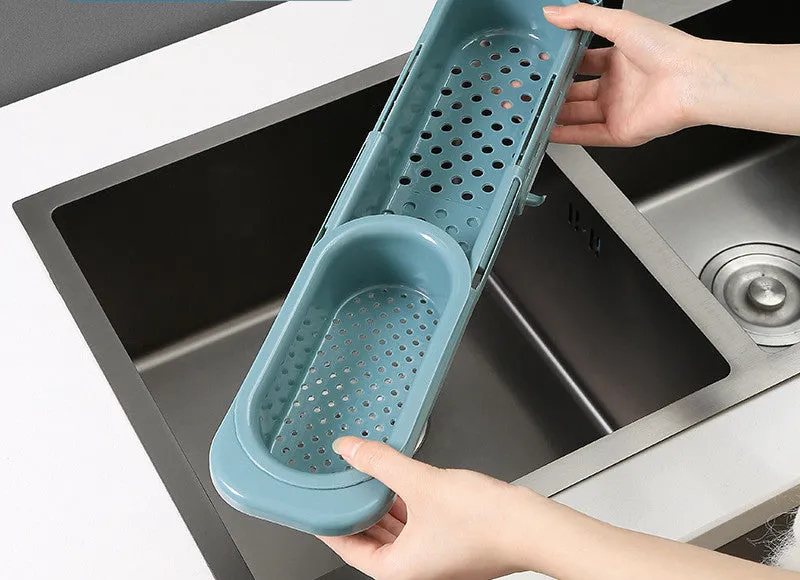 Blue grey telescopic sink rack holding a sponge and soap bar next to a kitchen tap